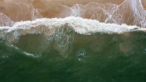 Descending-bird's-eye-aerial-shot-of-the-tropical-Rio-Grande-do-Norte,-Brazil-coastline-with-golden-sand,-turquoise-clear-water-and-waves-crashing-on-shore-in-between-Baia-Formosa-and-Barra-de-Cunha?