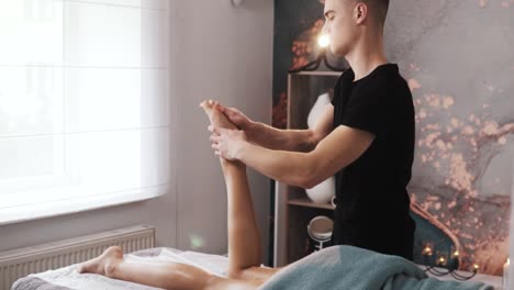 Allgemeine-Aufnahme-Eines-Männlichen-Masseurs-Im-Massagesalon,-Der-Eine-Fußmassage-Gibt