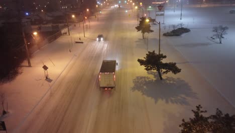 Aerial-show-of-trucks-on-the-road-during-winter-snowy-nights