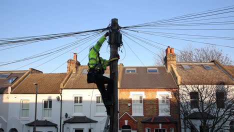Telecommunication-engineer-performing-maintenance-on-cables-at-the-top-of-a-telephone-pole