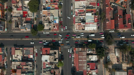 Flying-over-junction-with-moving-car-traffic-in-suburban-residential-district