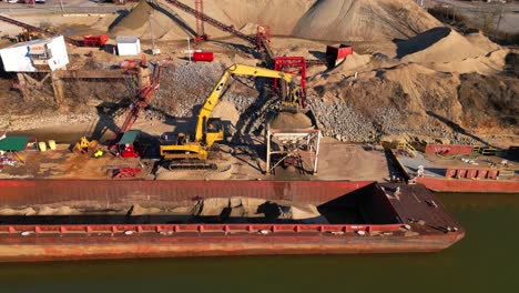 Aerial-flyaway-shot-of-excavator-unloading-sand-from-barge-on-the-Cumberland-River-in-Clarksville-Tennessee