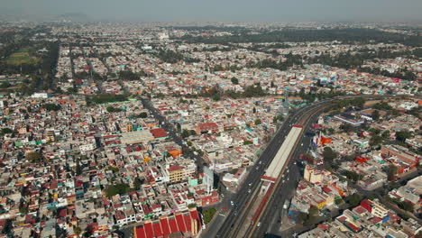Vista-Aérea-Del-Horizonte-De-La-Ciudad-De-México-Con-Autopista-De-Varios-Carriles-Concurrida-Y-Con-Tráfico