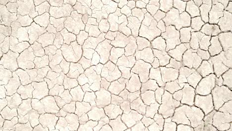 Cracked-dry-land-pattern,-aerial-top-down-ascend-view