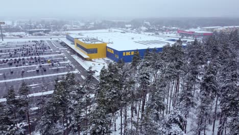 Ikea-furniture-store-surrounded-by-coniferous-forest-in-winter,-dolly-right