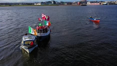 Traditional-fishing-boats-bobbling-at-sea-with-waving-Irish-and-galway-flags
