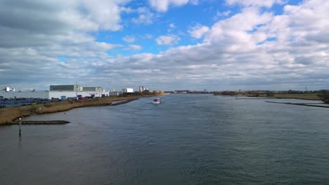 Frachtschiffe-Segeln-Auf-Dem-Fluss-Schelda-In-Der-Nähe-Von-Zwijndrecht,-Niederlande,-Panoramablick,-Fliegen-über-Den-Fluss-Mit-Einem-Industrieschiff,-Das-Tagsüber-Segelt