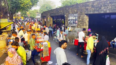 Eine-Statische-Aufnahme-Von-Menschen,-Die-Am-Eingang-Des-Gate-Way-Of-India-Streetfood-Essen