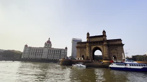 Eine-Aufnahme,-Die-Sowohl-Die-Prächtigen-Bauwerke-Des-Taj-Hotels-Als-Auch-Das-Gate-Way-Of-India-Einfängt,-Die-Eine-Große-Anzahl-Von-Touristen-Nach-Mumbai-Locken