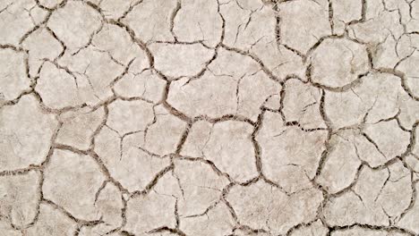 Dry-cracked-drought-fractured-land-aerial-view-rotating-over-hot-barren-environment
