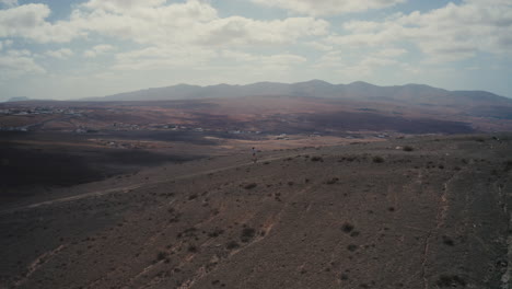 Tiro-De-Drone-De-Una-Niña-Caminando-En-Una-Montaña-En-Fuerteventura