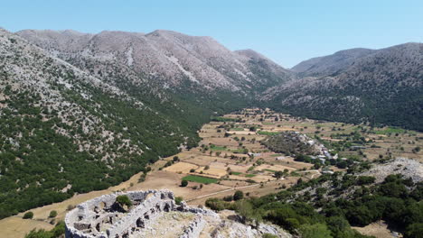 Aerial-backwards-with-view-of-Askyfou-Plateau-revealing-Turkish-fortress-ruins,-Crete