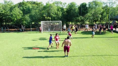 Hispanische-Familie-Spielt-Fußball-Auf-Dem-Fußballplatz,-Während-Eine-Der-Frauen-Den-Ball-Kickt
