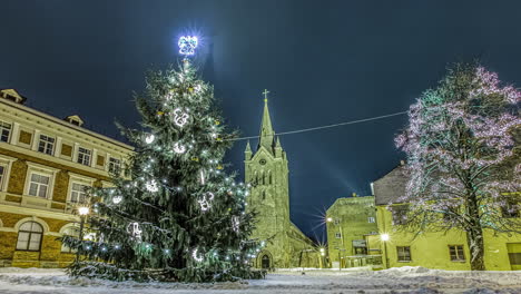Gleitender-Zeitraffer-Eines-Sich-Bewegenden-Beleuchteten-Weihnachtsbaums-Vor-Einer-Kirche