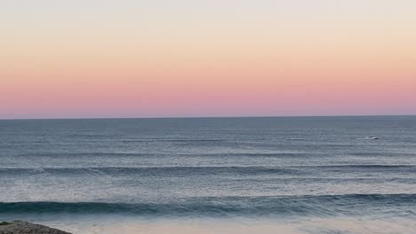 Weiter-Blick-Auf-Ein-Boot-Mit-Einem-Wunderschönen-Rosafarbenen-Sonnenaufgang-Im-Hintergrund
