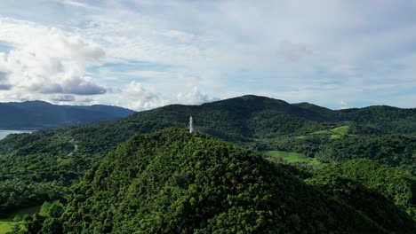Rotating,-Establishing-Drone-shot-of-island-lighthouse-on-top-of-jungle-covered-hills-in-Bato,-Catanduanes