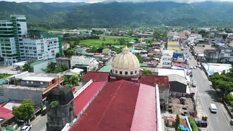 Eine-Atemberaubende-Luftaufnahme-Der-Virac-Kathedrale-Der-Unbefleckten-Empfängnis-In-Catanduanes,-Vor-Einer-Belebten-Straße