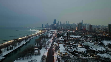 Drone-shot-over-snowy-cityscape-of-Lincoln-park,-towards-the-skyline-of-Chicago,-USA