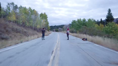 hikers-on-an-open-road-doing-a-photo-shoot-in-snow-basin-utah---AERIAL-DOLLY-FLY-BY