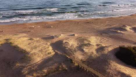 Menschen-Am-Strand-Von-Playa-Brava-Bei-Sonnenuntergang,-Stadt-Punta-Del-Este-In-Uruguay