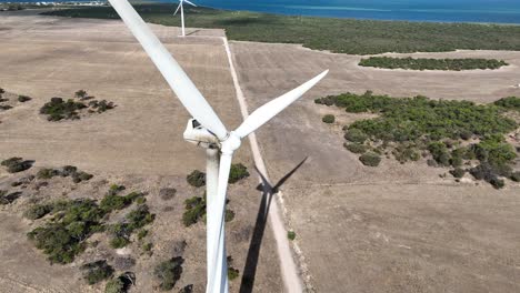 Descending-drone-shot-of-spinning-Wind-Turbine
