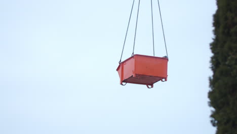 Orangefarbener-Container-In-Der-Luft,-Der-Eine-Baustelle-Bewegt