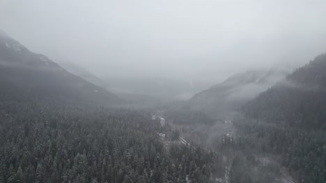 Ein-Kalter-Wintertag-Mit-Bergen,-Die-Mit-Nebel-Und-Schnee-Bedeckt-Sind
