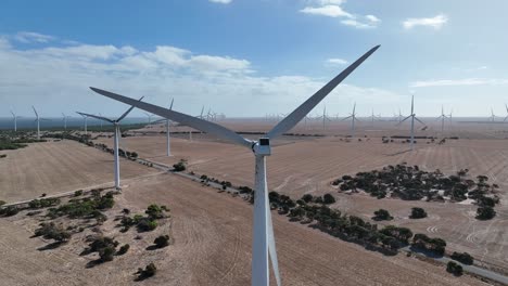 Stationary-drone-shot-of-spinning-wind-turbine