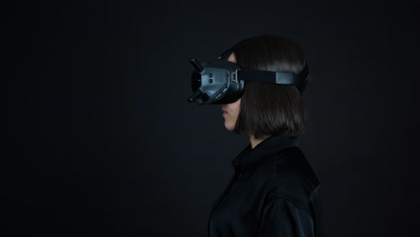 Junge-Frau,-Die-Eine-VR-Brille-Auf-Den-Kopf-Setzt,-Virtuelle-Realität-Und-Gaming-Konzept,-Schwarzer-Hintergrund