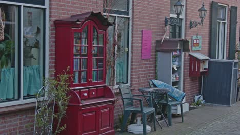 Close-pan-past-filled-bookcases-on-a-historical-old-road-in-the-small-castle-city-of-Bredevoort,-the-Netherlands