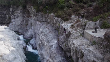 Persona-Cruzando-El-Río-Gorge-Sobre-Rocas-En-Góndola-Helambu,-Nepal