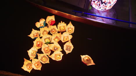 Top-down-shot-of-paper-candle-boats-floating-on-the-Hoi-An-river