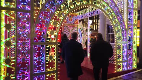 Walking-around-Covent-Garden-Christmas-light-show-in-London-in-December-2022-and-showing-how-busy-the-location-is-with-tourists-in-the-evening-during-this-festive-period