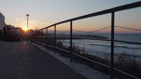 time-lapse-captures-street-sunrise-near-handrail-that-divides-coastline-from-seaside