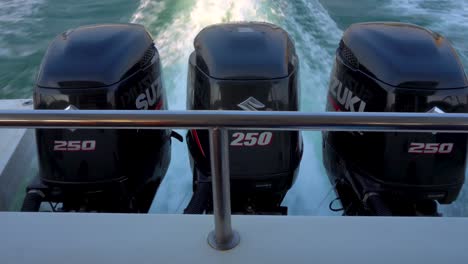Drei-Schwarze-Suzuki-Außenbordmotoren-Treiben-Das-Schnellboot-An-Und-Erzeugen-Kielwasser