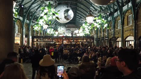 Caminar-Por-Covent-Garden-En-Londres-En-Diciembre-De-2022-Y-Mostrar-Artistas-Callejeros-En-Vivo-Y-Multitudes-Y-Mostrar-Cuán-Ocupado-Está-El-Lugar-Con-Turistas-Por-La-Noche-Durante-Este-Período-Festivo