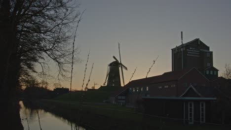 Fokusgestell-Vom-Schilf-Bis-Zur-Klassischen-Windmühle-In-Einer-Wunderschönen-Holländischen-Landschaft-Bei-Sonnenuntergang