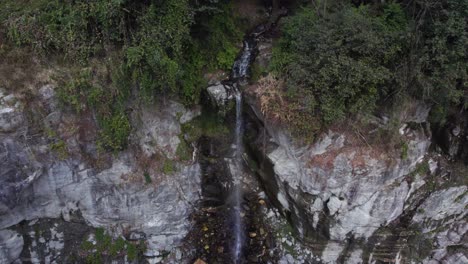 Aerial-Shot-Of-Small-Waterfall-Flowing-Out-Of-Rocks,-Helambu-Chofku-Village,-Nepal