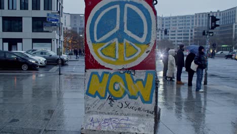 Part-of-the-Berlin-Wall-in-Potsdamer-Platz-square-on-a-rainy-day-with-tourists