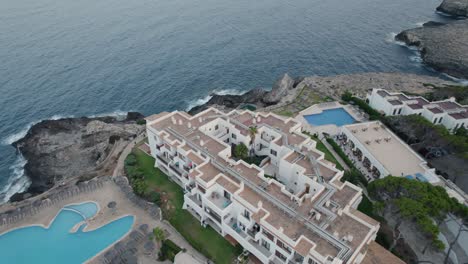 Aerial-view-from-a-luxury-hotel-with-swimming-pool-next-to-the-Mediterranean-sea-in-the-touristic-town-of-Cala-d´Or-in-the-Spanish-Island-of-Mallorca