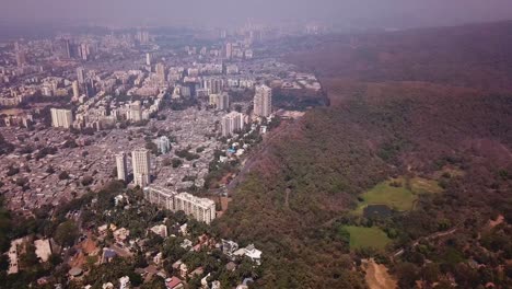 Vista-Aérea-De-Los-Suburbios-Residenciales-De-Mumbai-India-Y-El-Paisaje-Del-Parque-Nacional-Sanjay-Gandhi,-Disparo-De-Drones-De-Gran-Altura