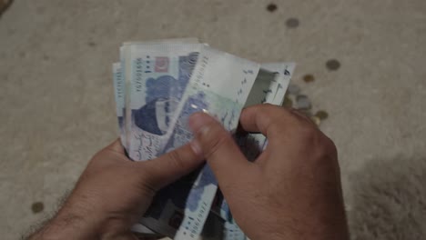 Hände-Zählen-Pakistanische-Banknoten-Im-Wert-Von-1000-Rupien