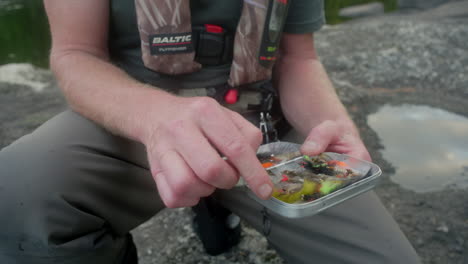 Flyfisherman-showing-off-different-flies-in-his-tackle-box