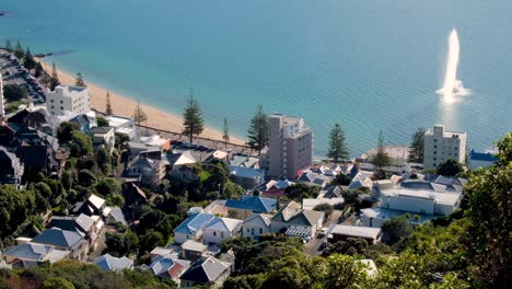 People-wandering-along-popular-Oriental-Bay-waterfront-with-views-of-Carter-Fountain-in-harbour-and-inner-city-beach-in-capital-city-Wellington,-New-Zealand-Aotearoa