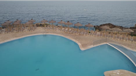 Luxury-swimming-pool-next-to-the-Mediterranean-sea-in-the-touristic-town-of-Cala-d´Or-in-the-Spanish-Island-of-Mallorca