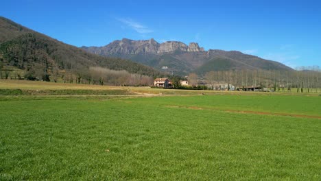 Imágenes-Con-Cardán-En-Un-Campo-Verde-Cultivado-Y-Montañas-En-El-Movimiento-De-Avance-De-Fondo