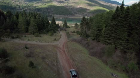 Off-Road-4x4-Four-Wheel-Drive-around-Lake-Doxa-Pine-Forest,-Greece,-Aerial-Drone-View