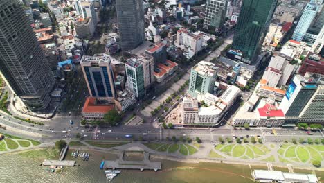 aerial-top-down-view-of-cars-and-motorbikes-driving-parallel-to-river-in-Saigon-Vietnam-on-sunny-day