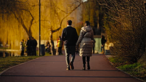 Romantic-walk-of-young-heterosexual-couple-in-a-park-at-sunset-time