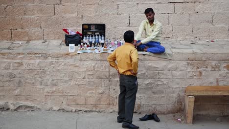 Two-men-talking-to-each-other-beside-a-roadside-shop-or-stall,-a-man-talking-to-his-friend-beside-his-shop-on-the-street